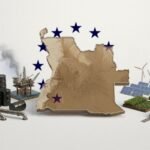 Angolan and European Union officials shaking hands in front of their flags after signing a partnership agreement on green investment and economic diversification.